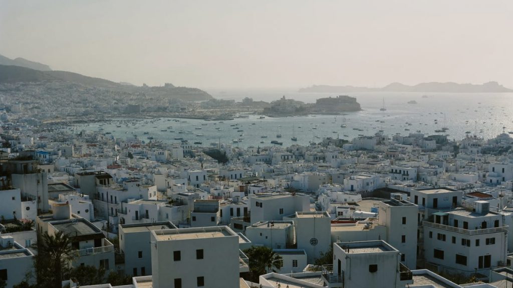 Vista elevada de una ciudad costera mediterránea de casas blancas junto al puerto